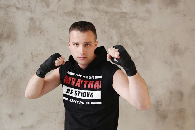 Young sportive man doing karate or boxing tricks