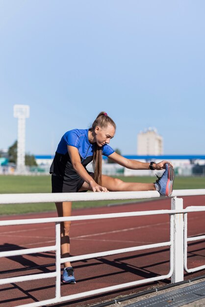 Young sportive at stadium stretching