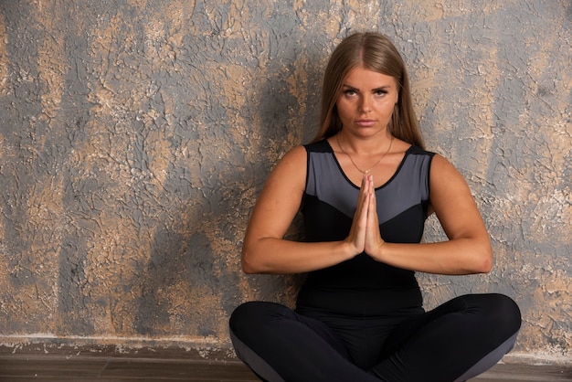 Young sportive woman doing meditation in lotus position