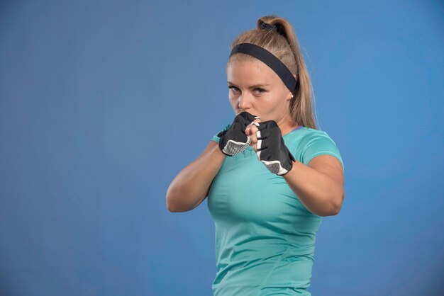 拳とボクシングを保持している若いスポーティーな女性。