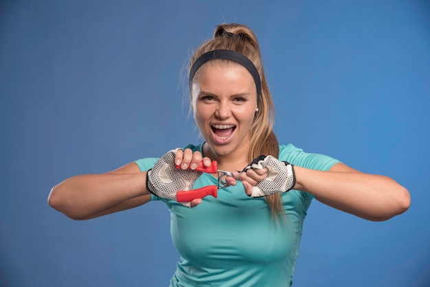 Free photo young sportive woman holding a hand stretching gum and looks strong.