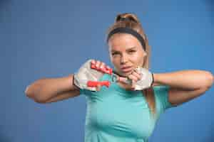 Free photo young sportive woman holding a hand stretching gum and looks tired.