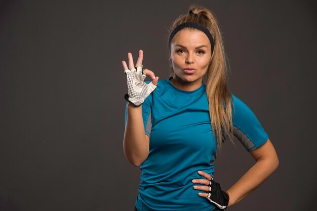 Young sportive woman making good hand sign after workout