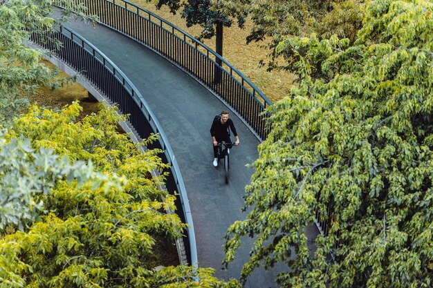 ヨーロッパの都市で自転車に乗っている若いスポーツ男。都市環境でのスポーツ。