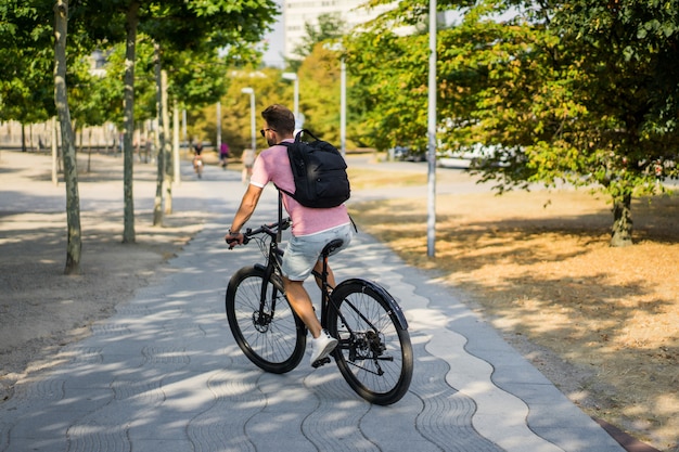 ヨーロッパの都市で自転車に乗って若いスポーツ男。都市環境におけるスポーツ