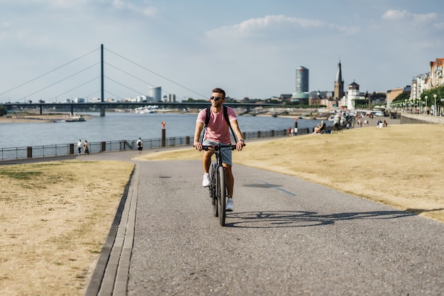 ヨーロッパの都市で自転車に乗って若いスポーツ男。都市環境におけるスポーツ