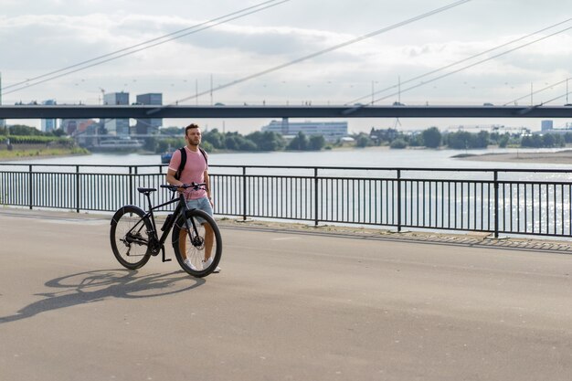 ヨーロッパの都市で自転車に乗って若いスポーツ男。都市環境におけるスポーツ