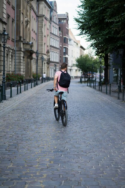 Young sports man on a bicycle in a European city. Sports in urban environments.