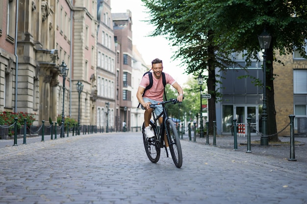 Young sports man on a bicycle in a European city. Sports in urban environments.