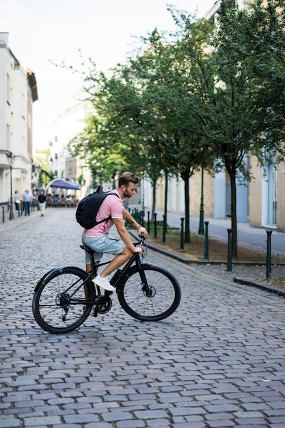 ヨーロッパの都市で自転車に乗って若いスポーツ男。都市環境におけるスポーツ