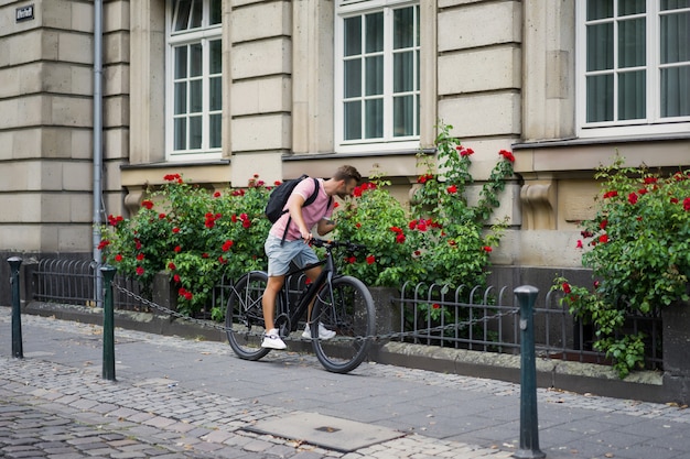 Young sports man on a bicycle in a European city. Sports in urban environments.