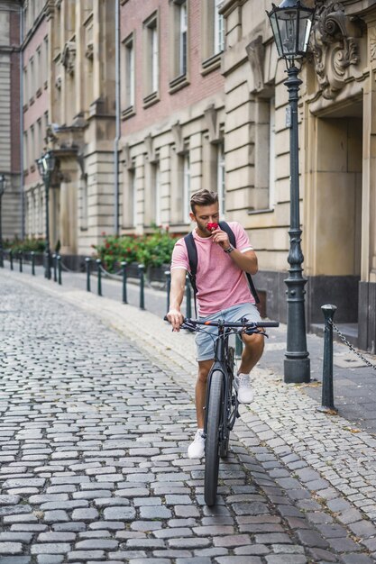 Young sports man on a bicycle in a European city. Sports in urban environments.
