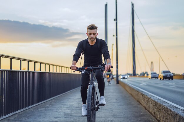 Young sports man on a bicycle in a European city. Sports in urban environments.