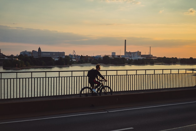 Young sports man on a bicycle in a European city. Sports in urban environments.