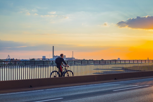 Young sports man on a bicycle in a European city. Sports in urban environments.