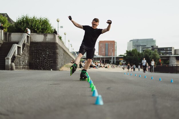 Молодой спортивный человек на роликовых коньках в европейском городе. Спорт в городских условиях.