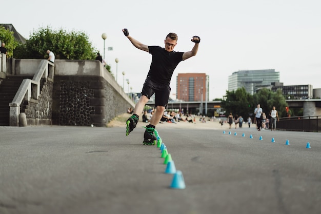 ヨーロッパの都市でローラースケートで若いスポーツ男。都市環境におけるスポーツ