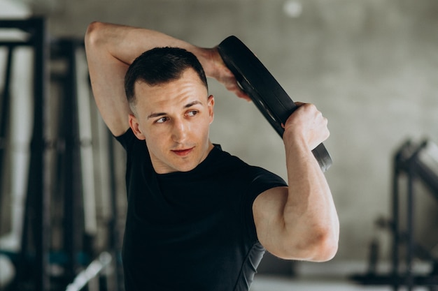 Young sports man training at the gym