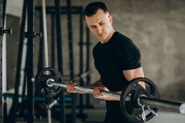 Young sports man training at the gym