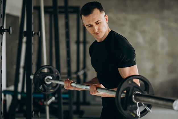 Young sports man training at the gym