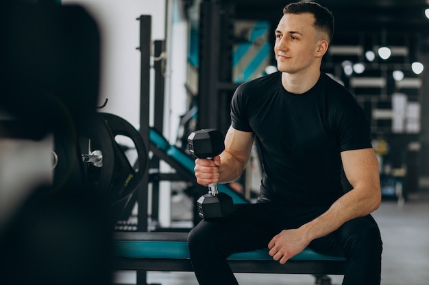 Young sports man training at the gym