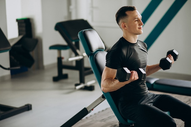 Young sports man training at the gym