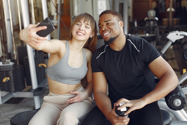 Young sports people sitting in a morning gym