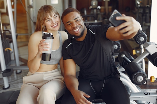 Young sports people sitting in a morning gym