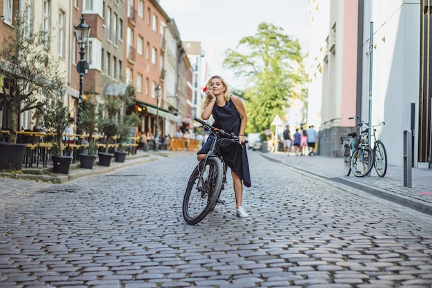 Молодая спортивная женщина на велосипеде в европейском городе. Спорт в городских условиях.