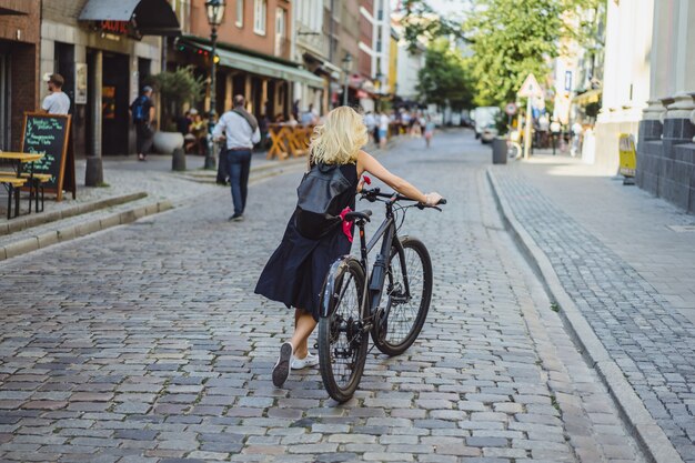 Young sports woman on a bicycle in a European city. Sports in urban environments.