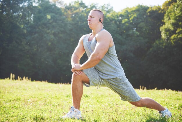 屋外での運動とフィットネスのトレーニングの準備をしている若いスポーツマン。