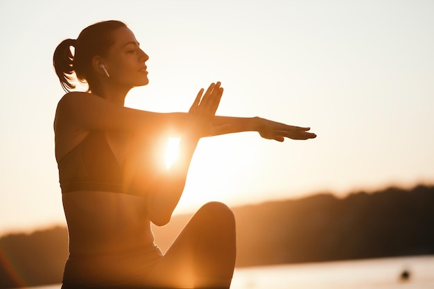 Young sportswoman exercising in the morning and stretching her arms