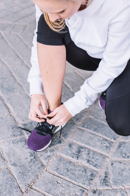 Young sportswoman tying laces