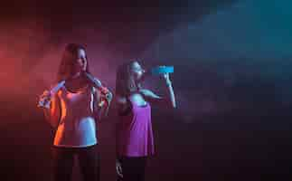 Free photo young sportswomen resting in dark studio