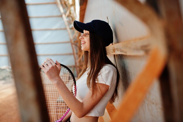 テニスコートでテニスラケットを持つ若いスポーティな女の子のプレーヤー