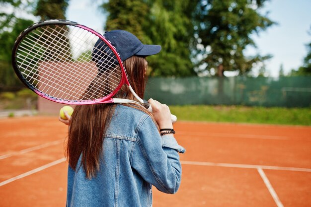 テニスコートでテニスラケットを持つ若いスポーティな女の子のプレーヤー