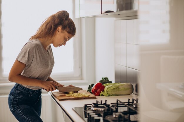 Young sporty woman cooking at the kitchen