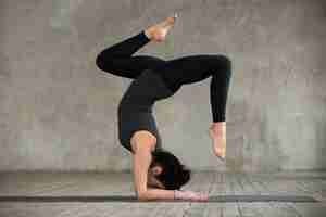 Foto gratuita giovane donna sportiva facendo esercizio pincha mayurasana