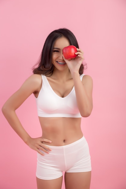 young sporty woman holds a fresh apple after a gym session promoting healthy eating and healthy lifestyle