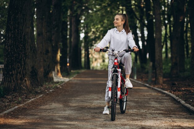 公園で若いスポーティな女性乗馬自転車