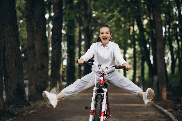 Young sporty woman riding bicycle in the park