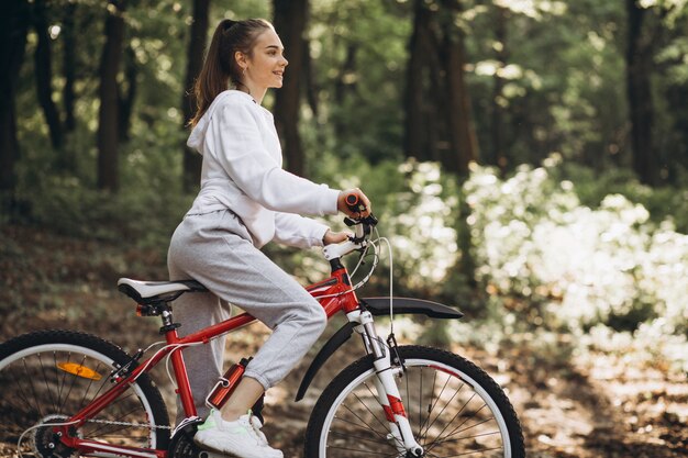 Молодая спортивная женщина езда на велосипеде в парке