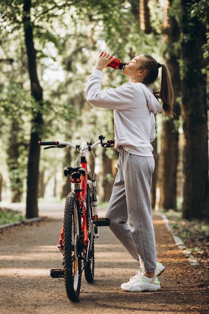 Young sporty woman riding bicycle in the park