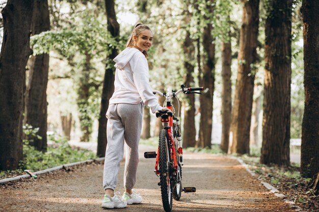 公園で若いスポーティな女性乗馬自転車