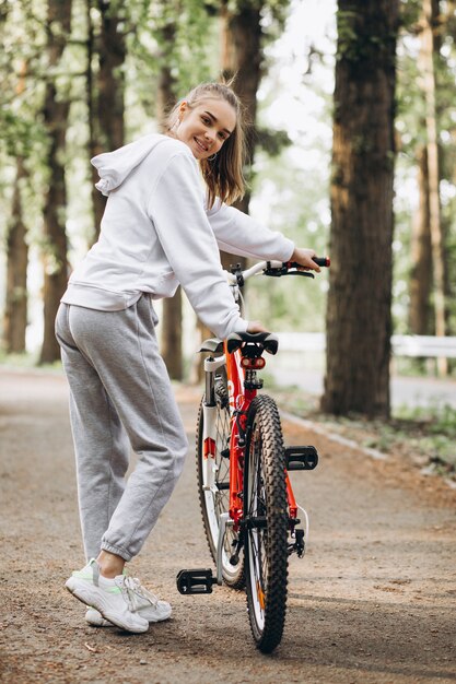 公園で若いスポーティな女性乗馬自転車