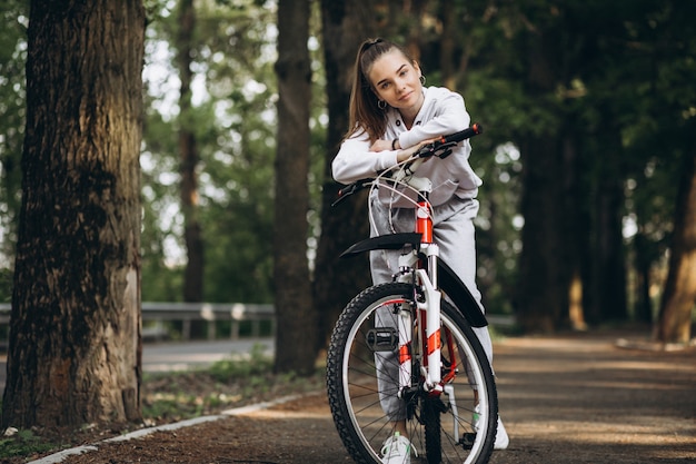 Young sporty woman riding bicycle in the park