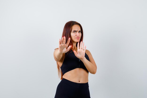 Молодая спортивная женщина показывает жест стоп
