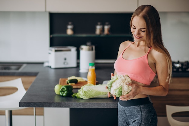 Free photo young sporty woman with cauliflower at the kitchen