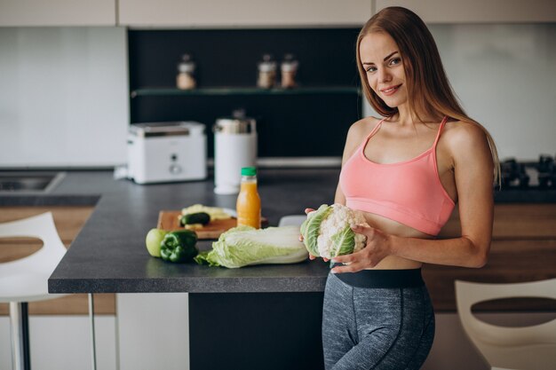 Young sporty woman with cauliflower at the kitchen