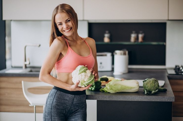 Free Photo young sporty woman with cauliflower at the kitchen